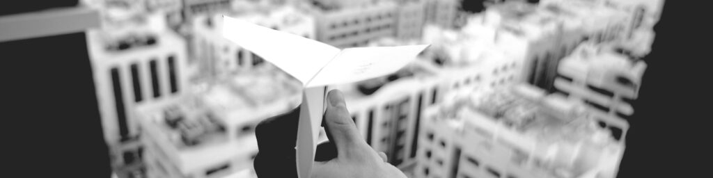Standing atop a skyscraper with a paper airplane represents a big first step in building a product innovation strategy
